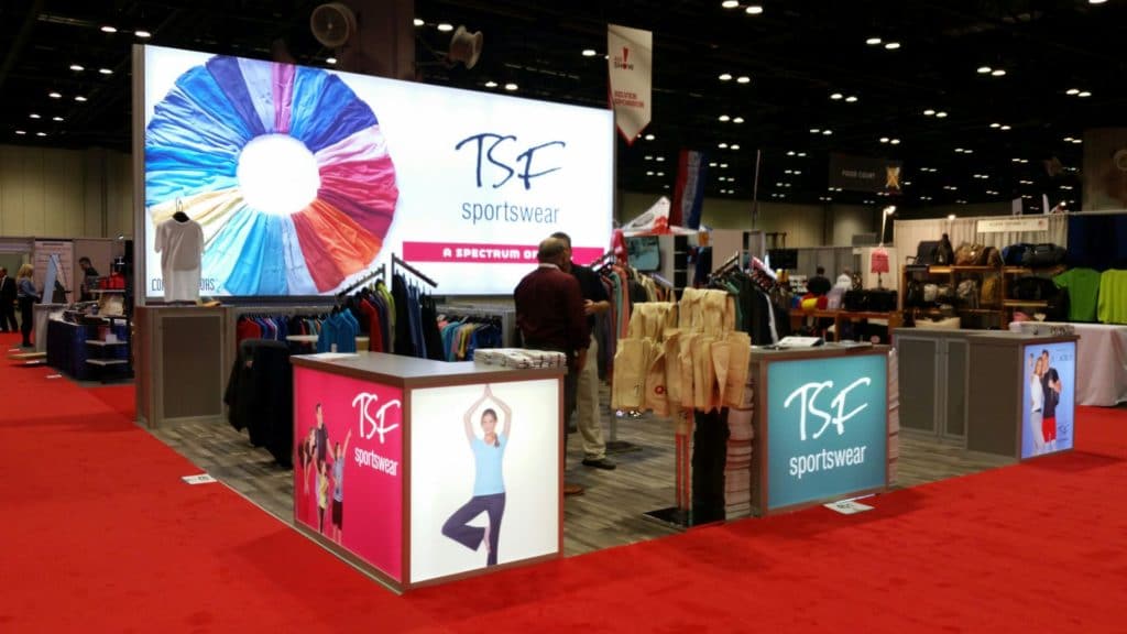 Trade show booth with innovative design showcasing clothing on neatly arranged racks, illustrating how to display clothing at a trade show effectively.